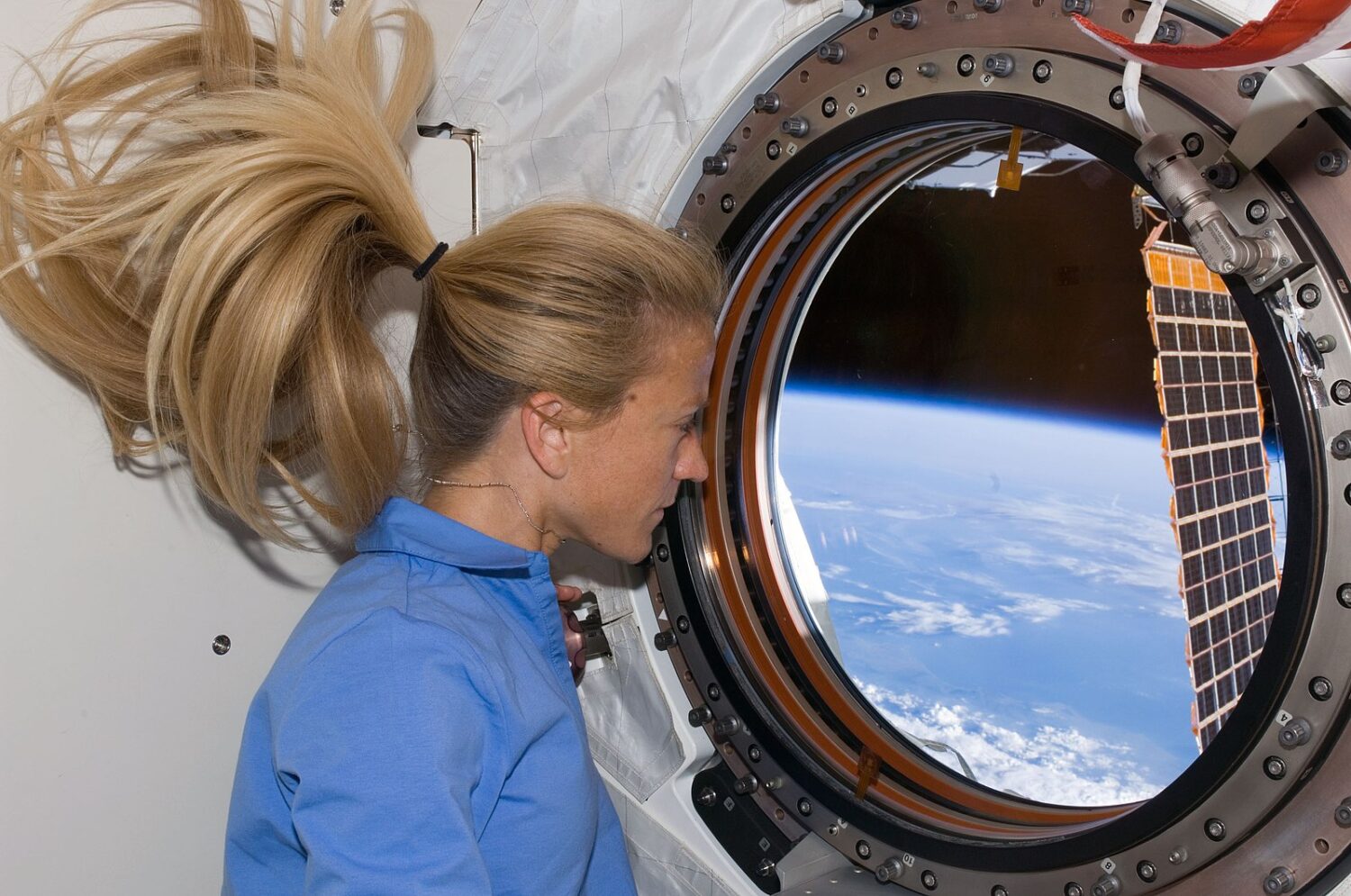 Chevelure en apesanteur de l'astronaute Karen Nyberg, qui observe la Terre par le hublot du laboratoire Destiny (2007).